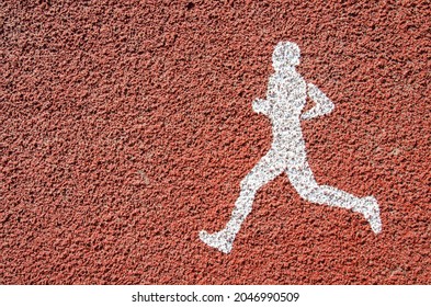 White Treadmill Symbol On Orange Asphalt For Running, Walking Or Jogging. Running Area In The Park. Runner Track With Copy Space. Jogging Area In The City. Sport And Healthy Lifestyle Concept.