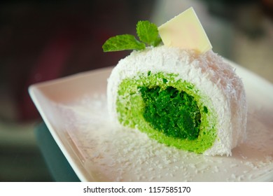 White Tropical Coconut Cake With Green Pandan Flavor On Shredded Coconut Filling, Topped  Mint Leaves And White Chocolate, Asian Sweet Delight Fruit Snack Dessert, Summer Food Collection Concept