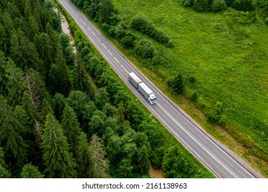 white truck driving on asphalt road on the highway. road through beautiful green forest. seen from the air. Aerial view landscape. drone photography. cargo delivery - Shutterstock ID 2161138963