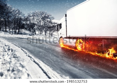 White truck with fiery wheels on a snow covered road