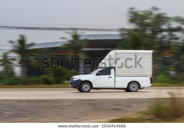 White\
truck moving at high speed with blurred\
background
