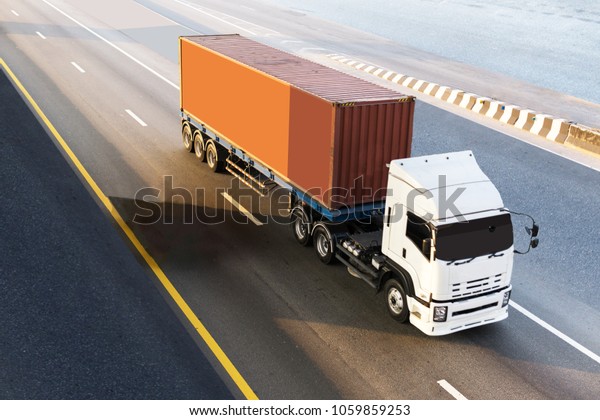 White Truck on highway road with red container,\
transportation concept.,import,export logistic industrial\
Transporting Land transport on the asphalt expressway.motion\
blurred to soft focus