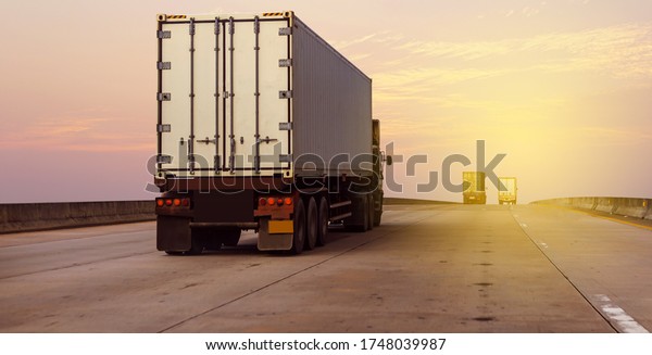 White Truck on highway road with  container,\
transportation concept.,import,export logistic industrial\
Transporting Land transport on the asphalt expressway against\
sunrise sky