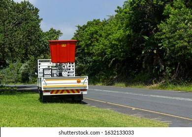 White Truck With Red Cherry Picker Crane Parked On The Side Of The Road