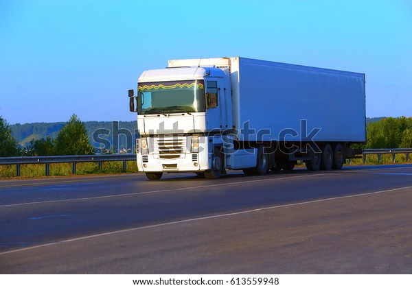 white\
truck transports freight on the country\
highway