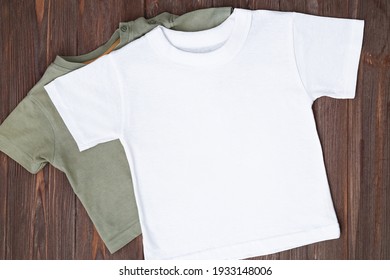 White Tshirt Mockup On Brown Wooden Background. Template, Flat Lay. Clothes Mockup, Kid Shirt.