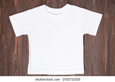 White Tshirt Mockup On Brown Wooden Background. Template, Flat Lay.