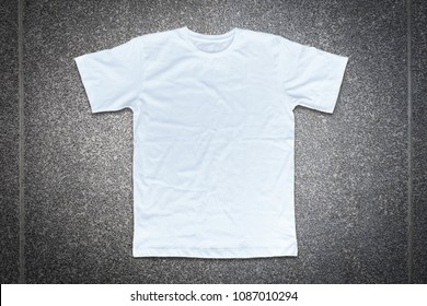 White t-shirt on concrete wall background.