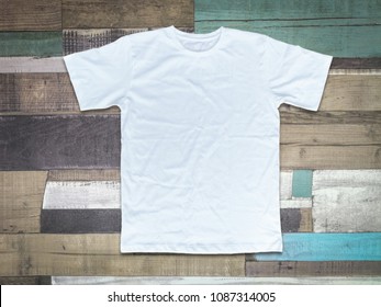 White t-shirt on wood background
