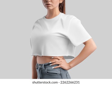 White t-shirt template, crop top on a girl in jeans, isolated on background, side view. Free cut t-shirt mockup, empty clothes oversized. Fashion shirt for design, print, brand, advertising