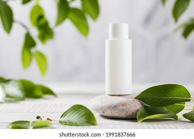 A White Tube Of Cosmetics On A Stone Among The Leaves. The Concept Of Natural Plant Cosmetics. Mockup.