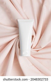 White Tube Cream Mockup On The Soft Pink Textile.