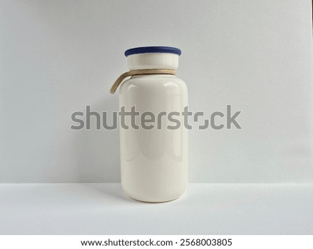 White Tumblr with blue list top cover and cream strap with white plain background and slight shadow