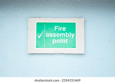 White turquoise rectangular sign on light blue painted stucco wall 