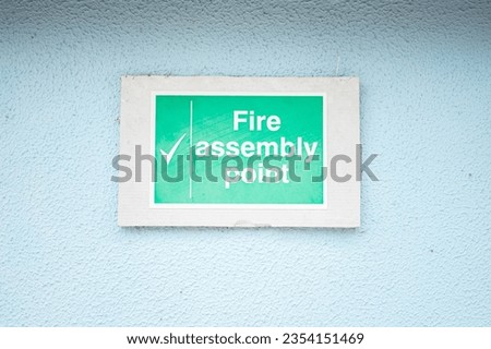 White turquoise rectangular sign on light blue painted stucco wall 