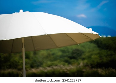 The white umbrella with the mountain and sky background - Powered by Shutterstock