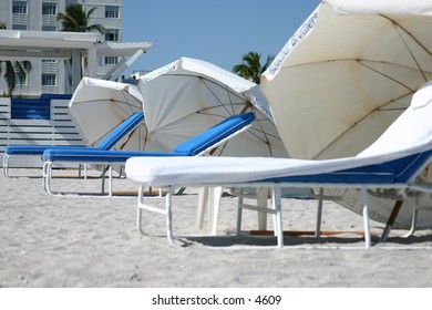 white umbrellas and lounge chairs on sandy beach
