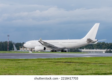 White unmarked passenger jet waiting for permission to take off. White aircraft on the runway.