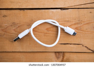 White USB Cable (USB Chord) On A Wooden Ground, Flat Lay (top View), Close Up