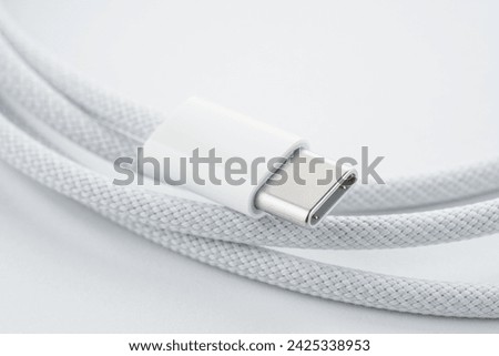 A white USB type C charger cable, compatible for many devices, wrapped in a spiral shape, isolated on white background. White simple USB lightning cable, rolled up	