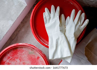 White Used Latex Gloves Lie On A Red Bucket Lid