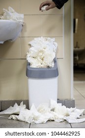 White Used Paper Tissue In Overcrowded Bin/Male Hand Drops Paper Tissue In Full Trash Bin/utilized Toilet Paper Dropped Around The Trash Basket, Vertical/ Dirty Toilet Concept