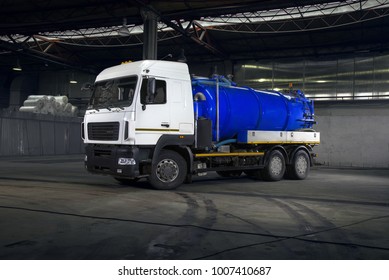White vacuum truck with blue tank in warehouse