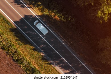 White van on the road, top down aerial view from drone pov, single vehicle on highway