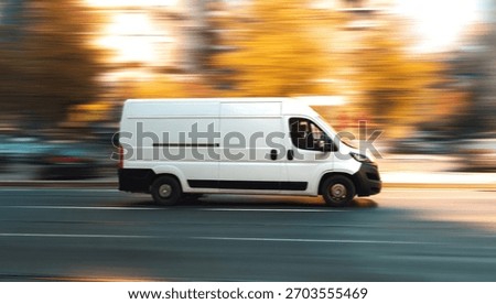 A white van is shown speeding down a road during the day with motion blur.