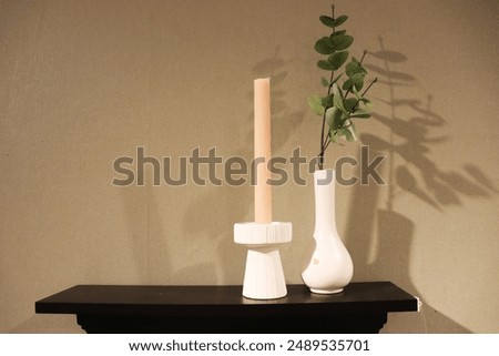 white vase and candlestick on the table in the interior of the room
