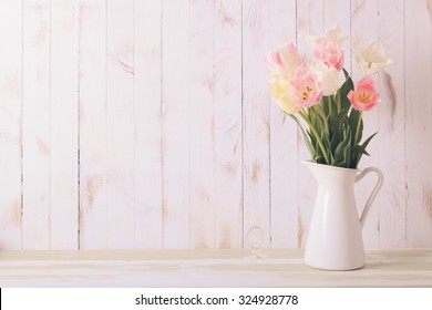 White Vase With Delicate Shades Armful Of Tulips On A Wooden Background