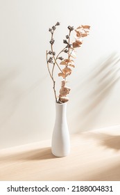 Jarrón blanco aislado en un fondo de madera. Jarrón minimalista. Flor seca. Diseño del producto. Simplicidad. Objeto. Jarrón de cerámica. Moderno. Decoración casera. 