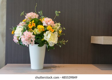 A white vase of many flowers on the table 