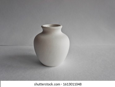 A White Vase On A Plaster Table