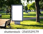 White vertical advertising poster on the grass. Blank banner in the park. Billboard in the city center mock up. LightPoster. Empty billboard idea concept. Copy space, text area. Outdoor.