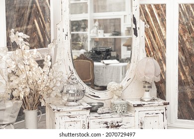 White Vintage Dressing Table With Retro Lamp, Antique Vases, Dried Flowers In Light Shabby Chic Vintage French Provence Country Interior Room With Wooden Parquet And Painted Furniture
