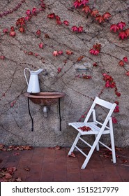 White Vintage Metal Jug On Ceramic Sink And Chair In Backyard In Garden. Autumn In Shabby Chic Style