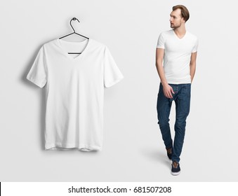 White v-neck t-shirt on a man in jeans, isolated, mockup. Hanging blank v-neck t-shirt, against empty wall.