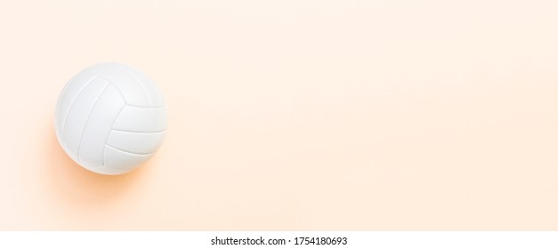 White Volleyball Leather Ball On Light Orange Color Background. Top View.