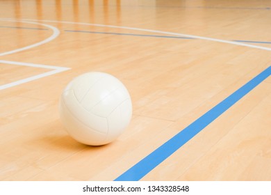 White Volleyball On The Ground In The School Gym