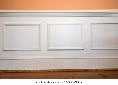 white wainscoting and chair rail on wall of orange peach dining living room of colorful home house
