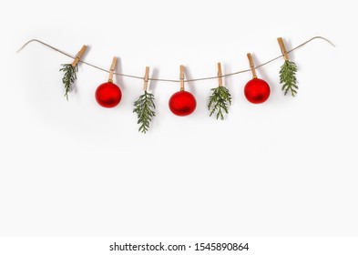 White wall background with christmas composition. Retro rope girland made of three red balls and fir branches. Christmas, cold winter, happy new year. Flat lay photo, top view, copy space.  - Shutterstock ID 1545890864