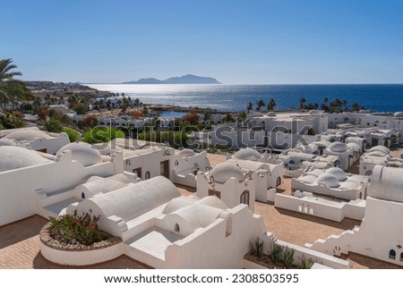 White wall buildings near Red sea on the tropical beach on sunny day in resort town Sharm El Sheikh, Egypt, architecture concept