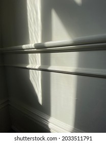 White Wall With Chair Rail Molding And Window Shadows Cast