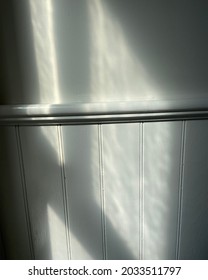 White Wall With Chair Rail Molding And Window Shadows Cast