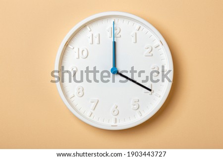 white wall clock with blue second hand show four o'clock