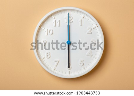 white wall clock with blue second hand show six o'clock
