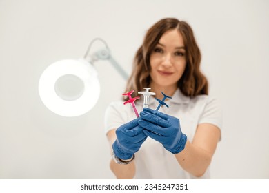 White wall. Cosmetologist holding syringes for injection lips augmentation. Women's cosmetology in the beauty salon. - Shutterstock ID 2345247351