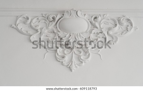 White wall molding with geometric shape and\
vanishing point. Luxury white wall design bas-relief with stucco\
mouldings roccoco element