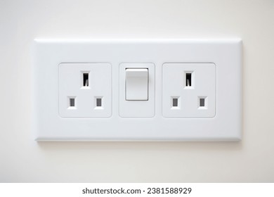 White wall mounted socket board with two electrical sockets and a switch. The socket board is isolated on a white background